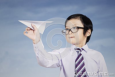 Business kid holding paper airplane outdoor