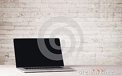 Business laptop with white brick wall