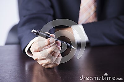Business man’s hands holding the pen