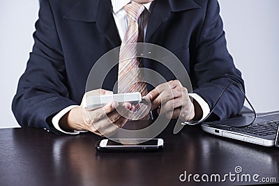 Business man charging his mobile phone