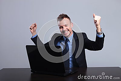 Business man cheers at laptop