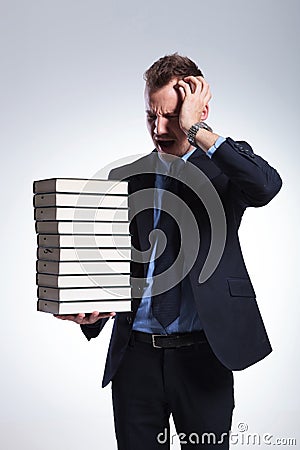 Business man has headache from books