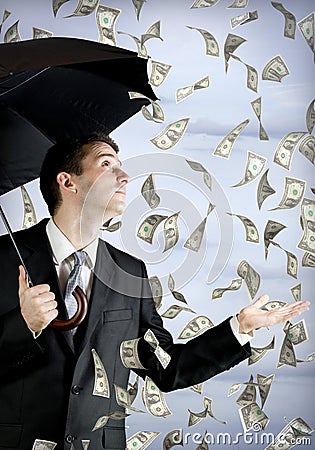 Business man holding an umbrella, money falling