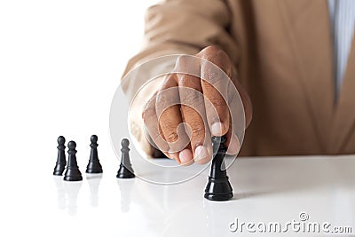Business man moving chess figure with team behind - strategy or