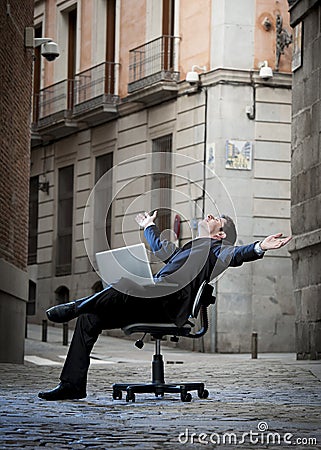 Business Man sitting on Office Chair on Street with Computer