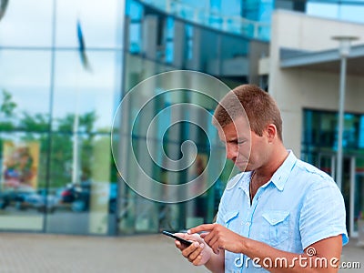 Business man speaking on phone in front of modern business building