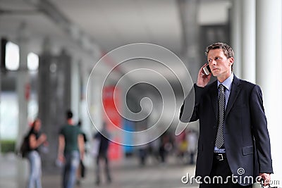 Business man talking on the phone in the crowd