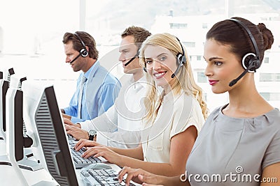 Business people with headsets using computers in office