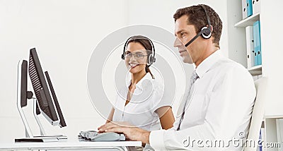 Business people with headsets using computers in office