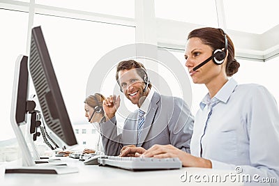 Business people with headsets using computers in office