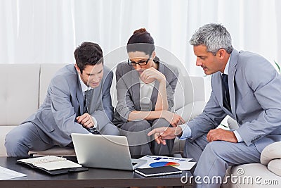 Business people using laptop and working together on sofa