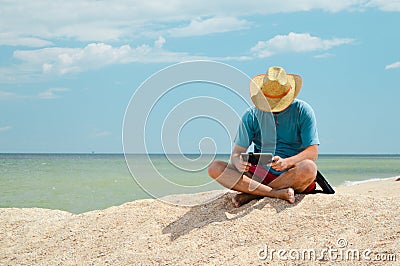 Business resting man sitting at seaside with tablet computer