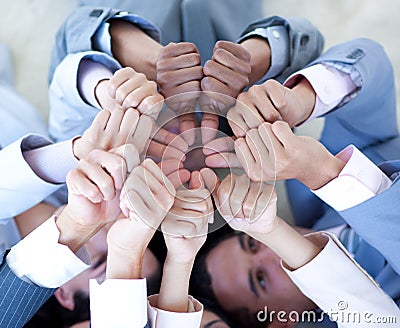 Business team on floor in a circle with thumbs up