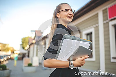 Business woman in black dress in the city with documents