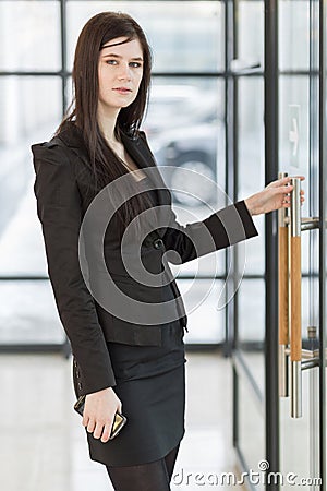 Business woman holding the door handle