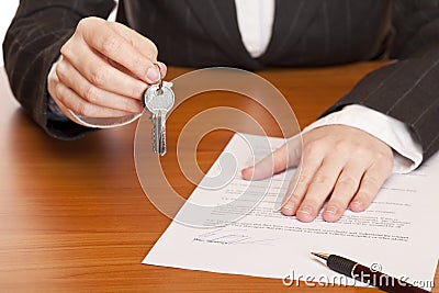 Business woman holds key and contract in hands