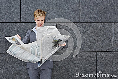 Business woman reading newspaper in windy weather