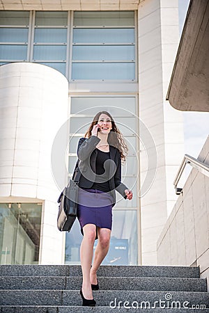 Business woman walking on stairs calling phone