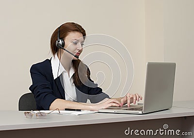 Business woman work on laptop in headset