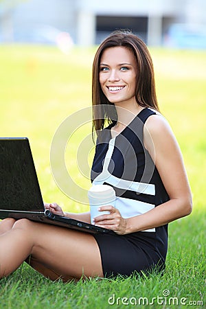 Business woman working on laptop outside in park