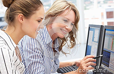 Business women working together on computers