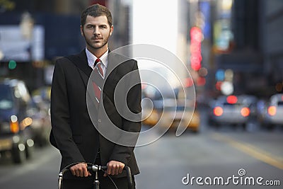 Businessman With Bicycle On Urban Street