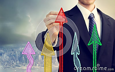 Businessman drawing rising arrows