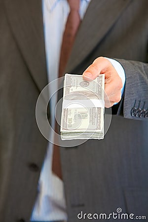Businessman giving stack of dollars. Close-up.