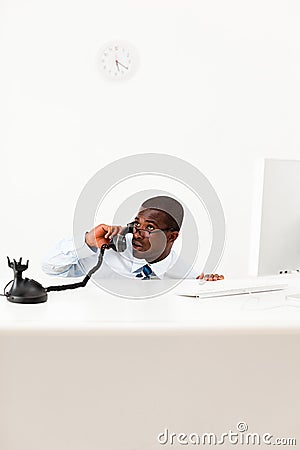 Businessman hiding behind desk