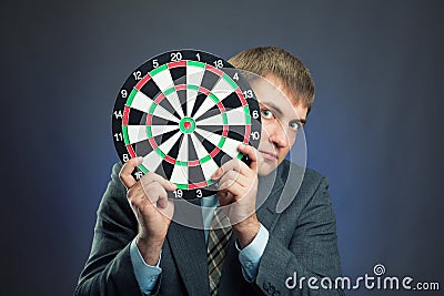 Businessman holding darts board in his hands