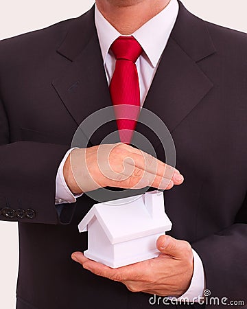 Businessman holding house in the hands.