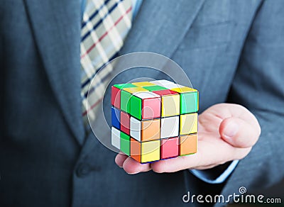 Businessman holding rubik cube in his hands