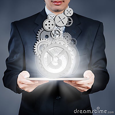 Businessman holding tablet showing gears, business strategy conc