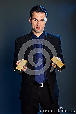 Businessman holds gold brick