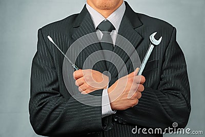 Businessman holds tools, concept of business creation