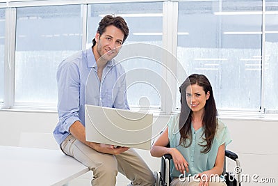 Businessman with laptop and businesswoman in wheelchair