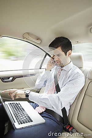 Businessman with laptop in his car