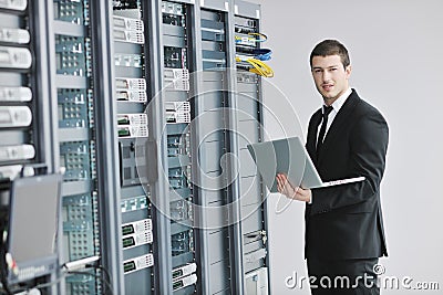 Businessman with laptop in network server room