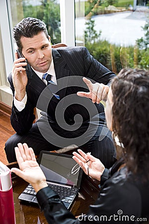 Businessman listening to mobile phone in meeting