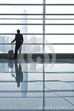 Businessman Looking Through Window At Airport