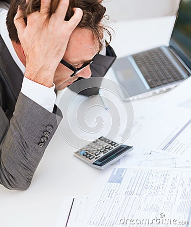 Businessman with papres, laptop and calculator