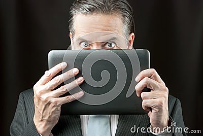 Businessman Peeks Over His Tablet