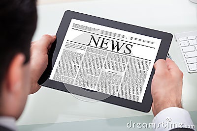Businessman reading news on digital tablet
