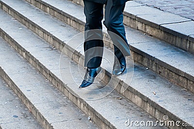 Businessman running down city stairs