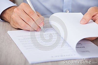 Businessman signing contract at desk