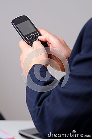 Businessman typing on the mobile phone