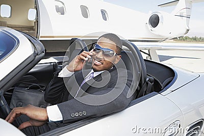 Businessman Using Cell Phone In Convertible