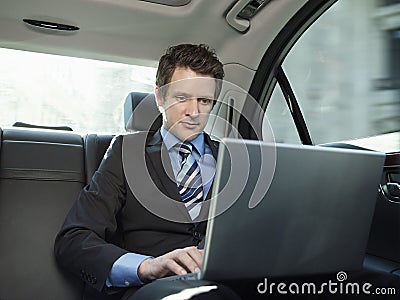 Businessman Using Laptop In Car
