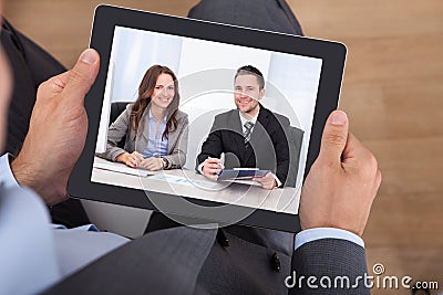 Businessman video conferencing with colleagues on digital tablet