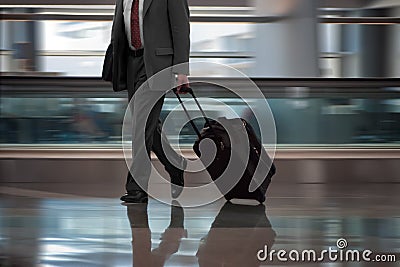 Businessman walking in airport with suitcase